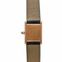 The Cartier Tank Normale features a gold rectangular case, black and beige leather strap, blue-tipped crown, and Made in France engraving.