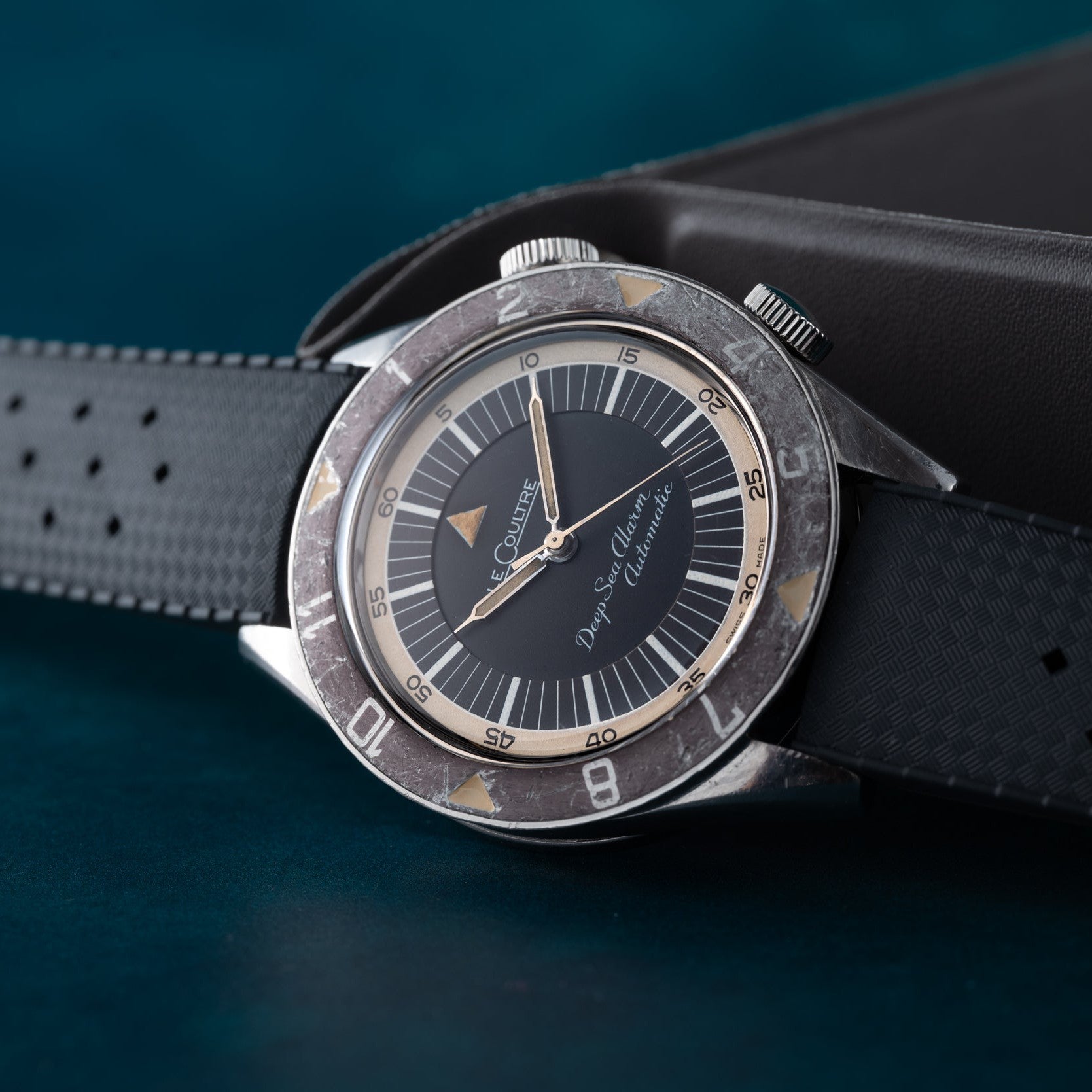 Jaeger-LeCoultre Deep Sea Alarm U.S. Edition wristwatch with a black dial and rubber strap resting on a dark surface.