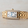 The Cartier Tank Americaine Diamond watch features a rectangular face with Roman numerals and sparkling diamond accents.