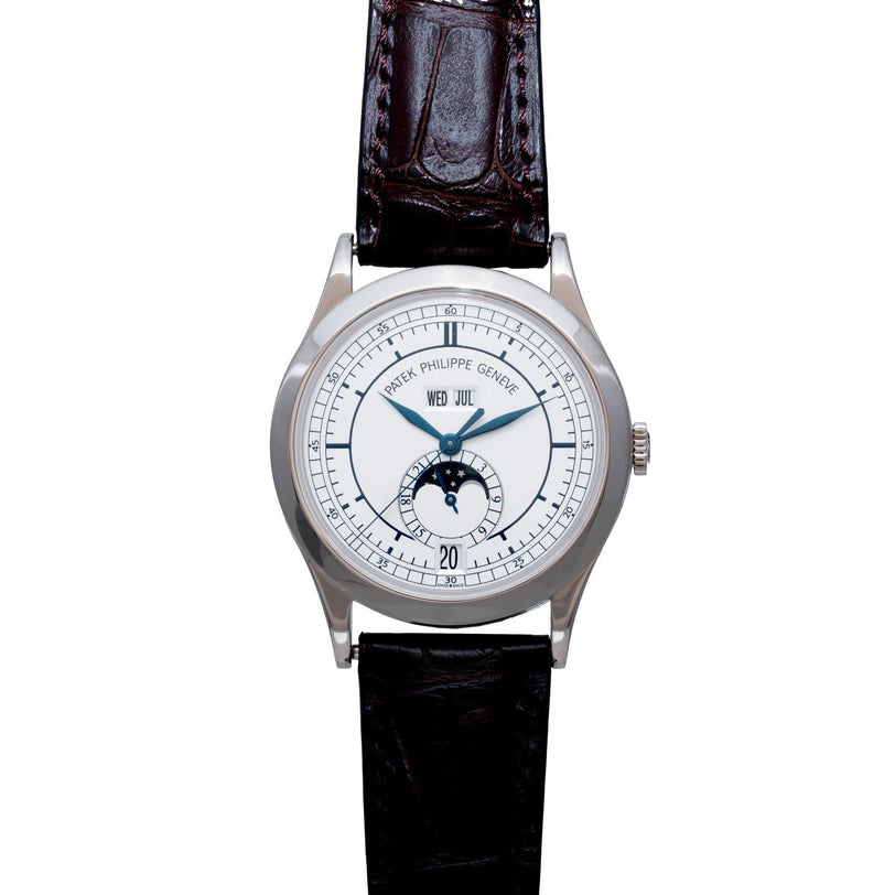 The Patek Philippe Annual Calendar is a luxury wristwatch featuring a white dial, black leather strap, and moon phase display.