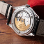Close-up of the back of the Patek Philippe Annual Calendar Moonphase watch, revealing its exposed mechanical movement and gold rotor.