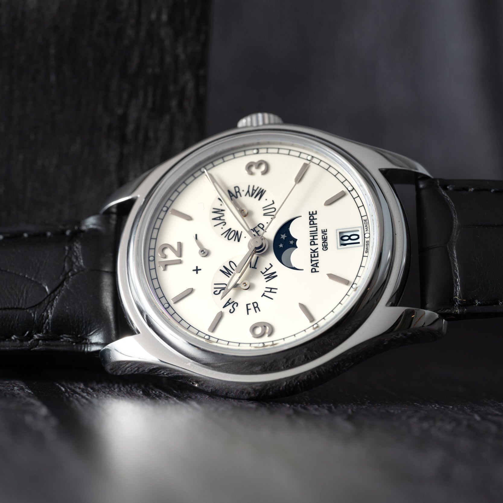 The Patek Philippe Annual Calendar Moonphase is a luxury wristwatch with a leather strap featuring date, day, month, and moon phase displays on its dial.