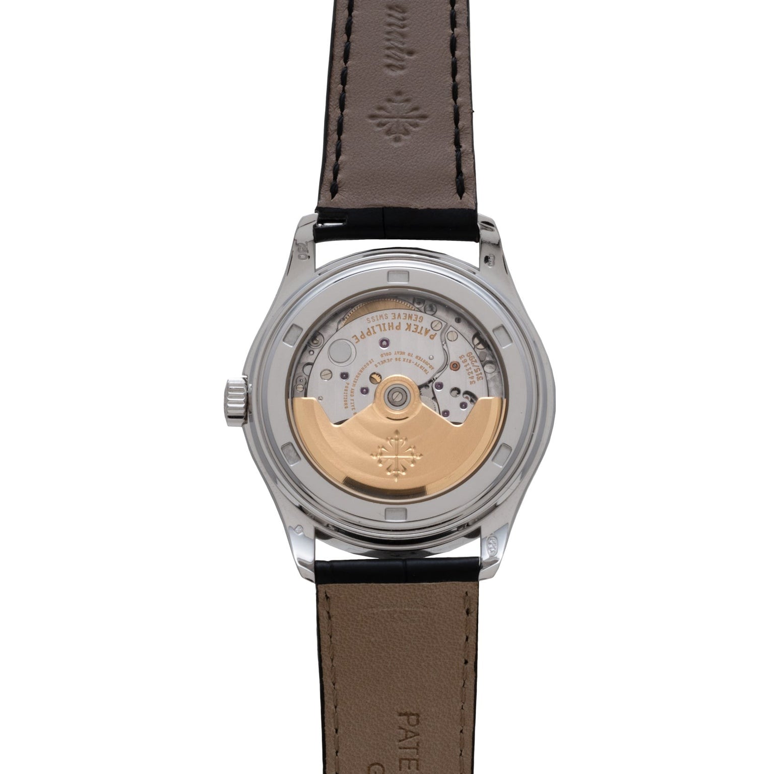 A close-up of the Patek Philippe Annual Calendar Moonphase watch’s exposed mechanical movement and rotor, visible through its transparent case back.