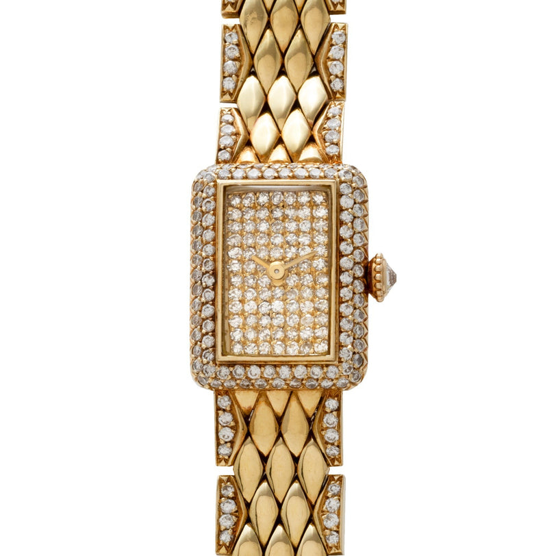 The Cartier Tank Mini Diamond is a gold wristwatch featuring a rectangular, diamond-encrusted face and band.
