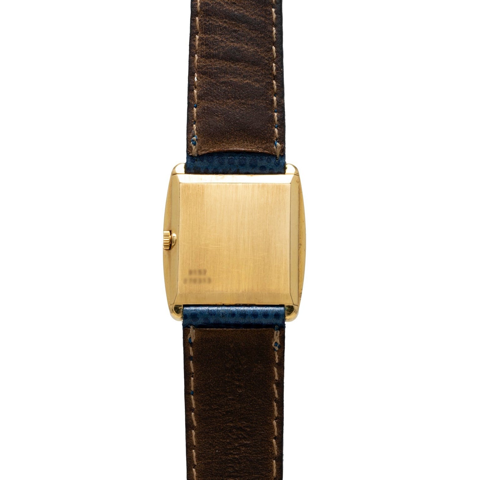 The Cartier Protocole gold rectangular watch features a brown leather strap, shown from the back with a plain case and visible stitching.