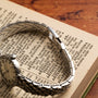 A Zenith Ladies Cocktail Watch lies on an open dictionary displaying the definition of artistic.