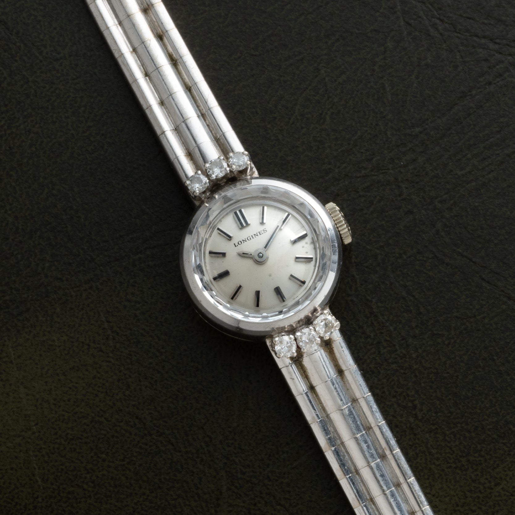 A Longines Diamond Cocktail Watch for women with a silver band and diamond accents, displayed on a dark background.