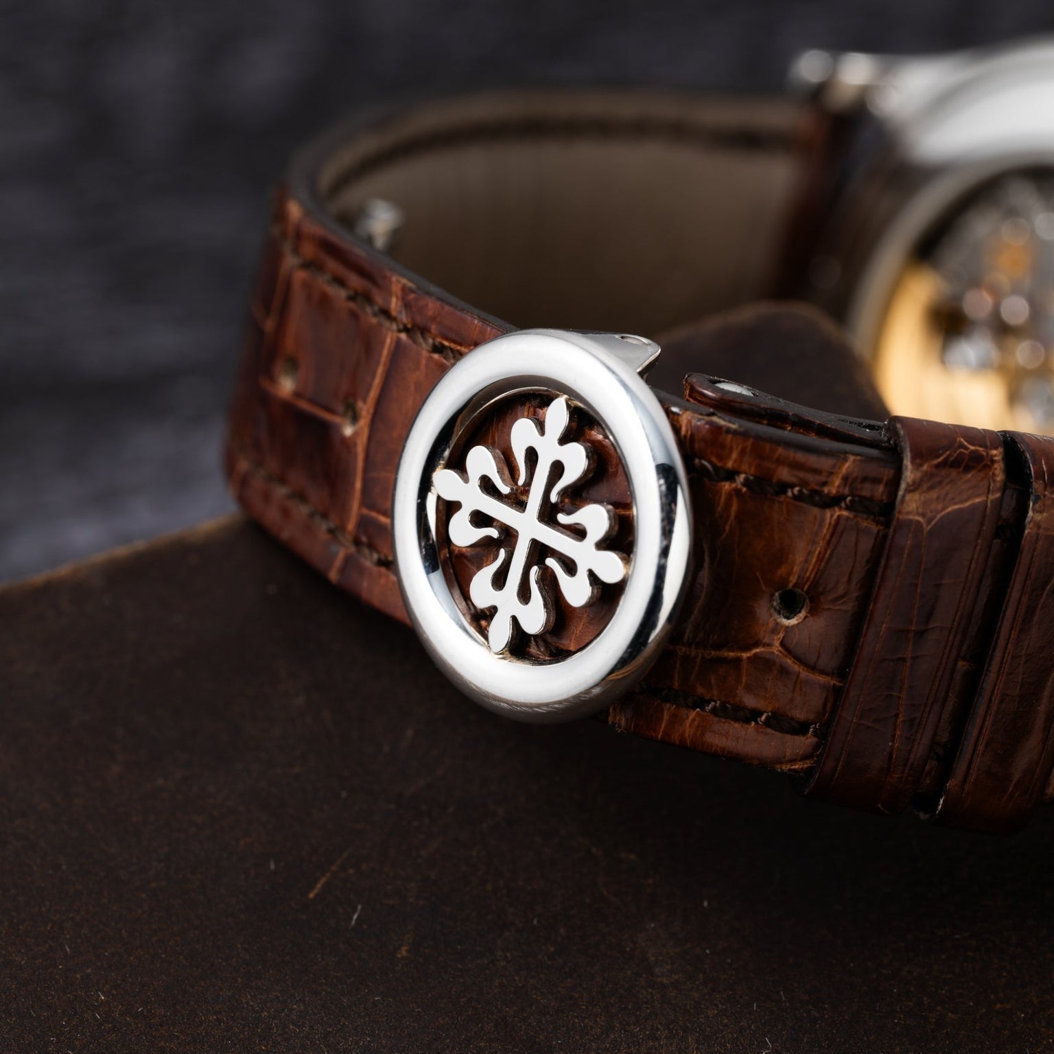Close-up of the Patek Philippe Retrograde Perpetual Calendars brown leather strap featuring a silver decorative emblem.