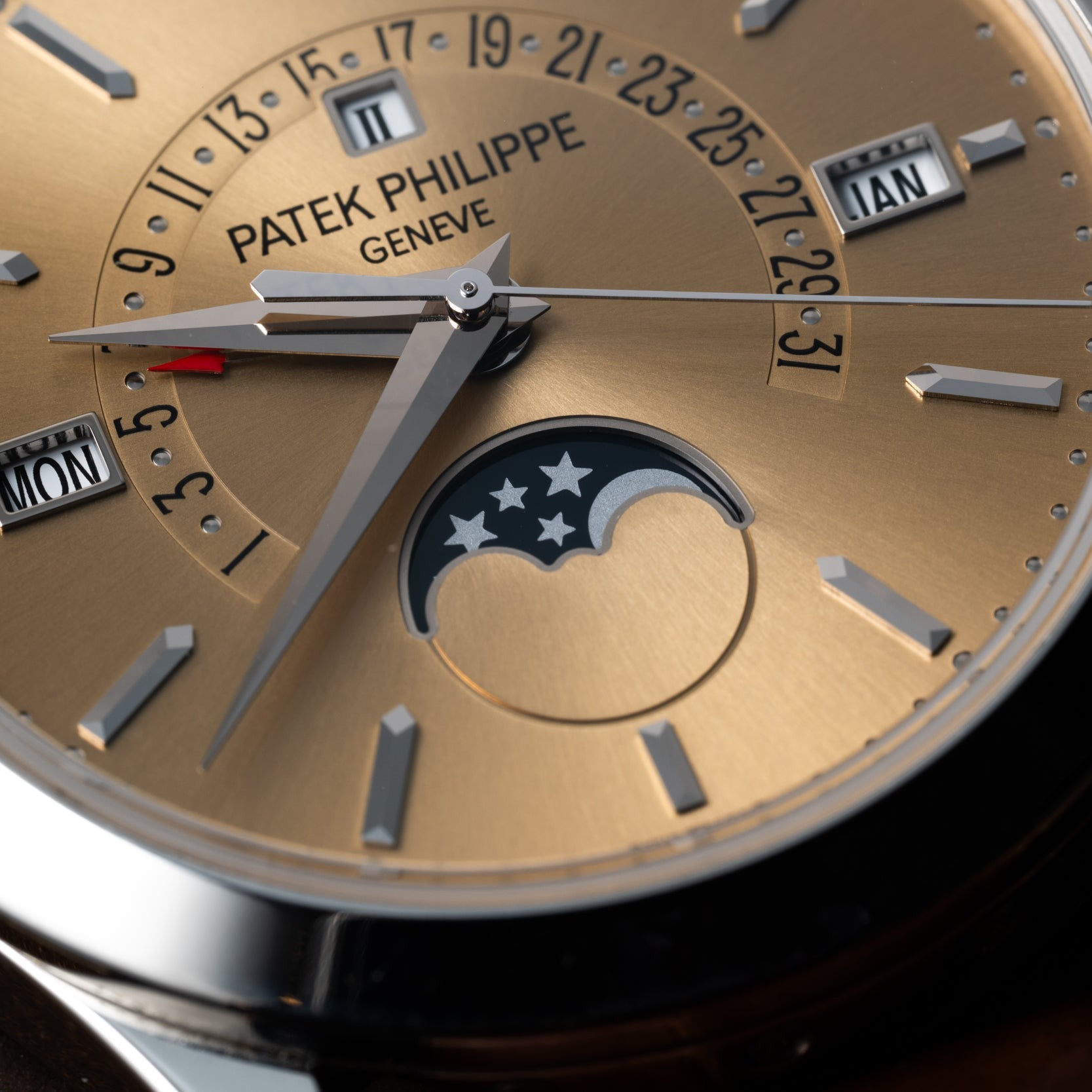 Close-up of a Patek Philippe Retrograde Perpetual Calendar watch face featuring gold details and moon phase, day, date, and month indicators.
