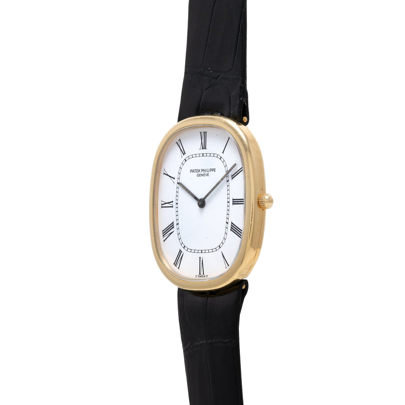 The Patek Philippe Ellipse is a gold wristwatch featuring a white face, Roman numerals, and a black leather strap.