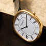 The Patek Philippe Ellipse is a gold oval wristwatch featuring Roman numerals and a black leather strap, with the time set to 1:00.