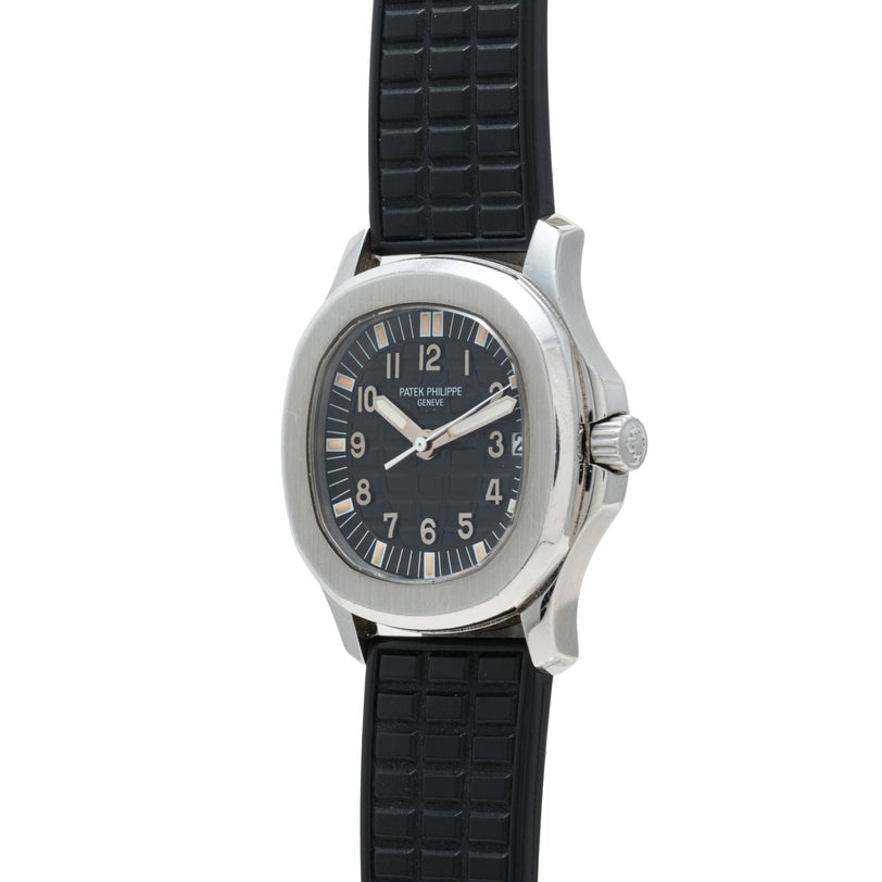 A Patek Philippe Aquanaut wristwatch featuring a silver case, black dial, and black textured rubber strap.