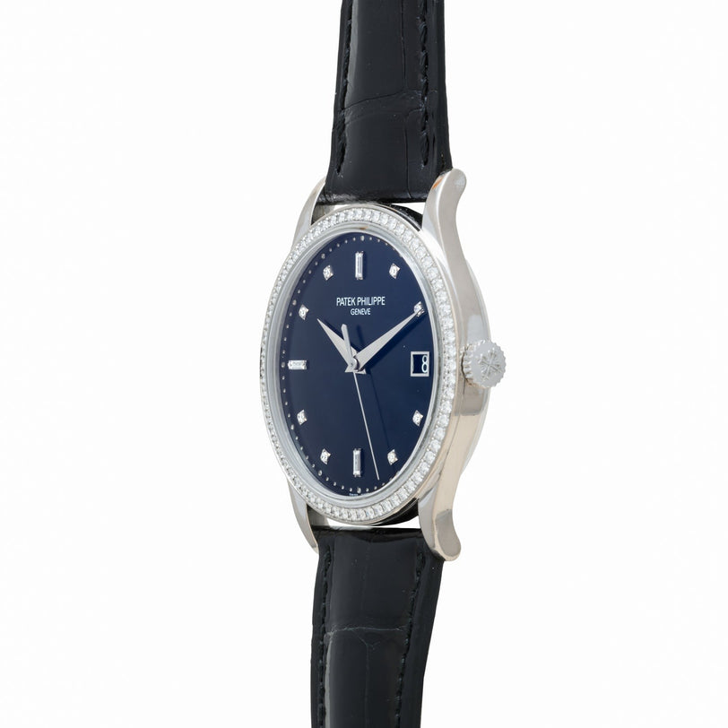 The Patek Philippe Calatrava Diamond Bezel is a luxury watch featuring a blue face, diamond markers, and a black leather strap, displayed at an angle to showcase its side.