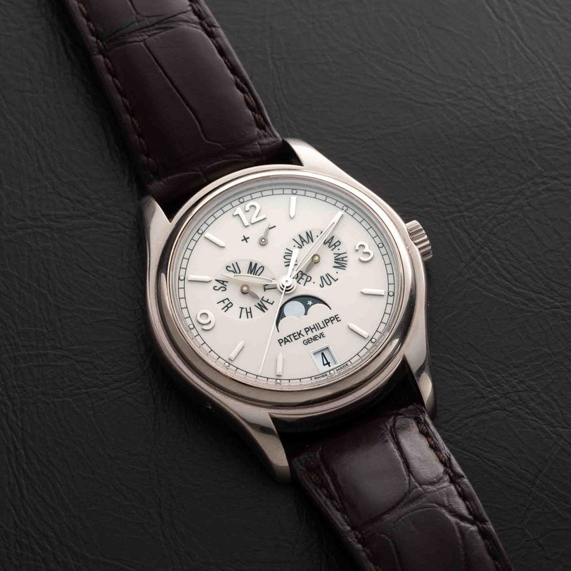 Patek Philippe Annual Calendar Moonphase watch with brown leather strap displayed on black leather.