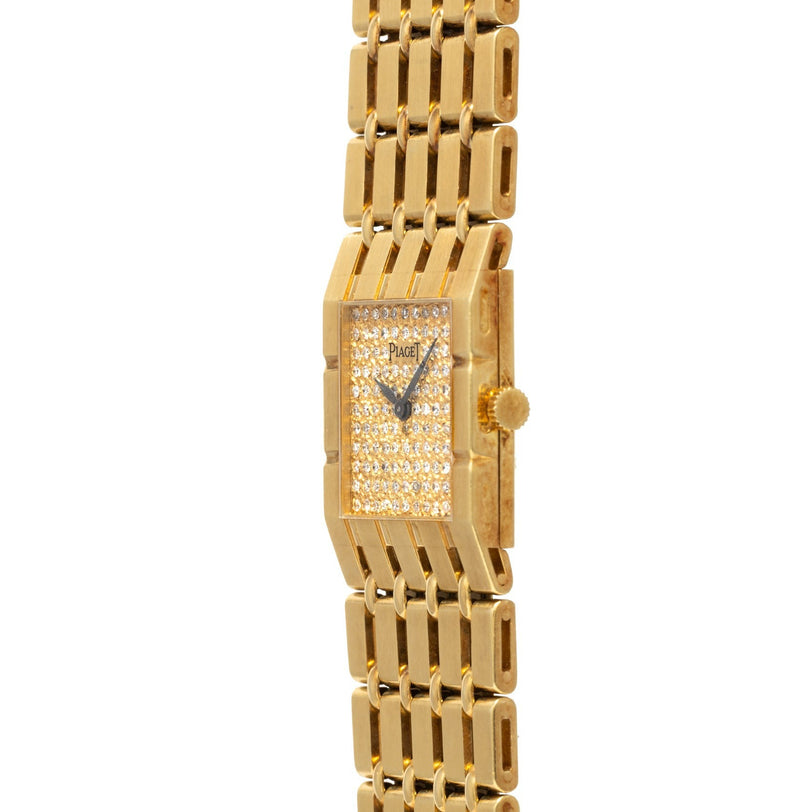 The Piaget Dancer gold wristwatch features a rectangular, diamond-studded face and gold link band, elegantly angled against a white background.