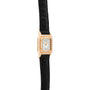 The Cartier Panthère is a gold watch with a diamond bezel and black leather strap, featuring a square white dial and Roman numerals.