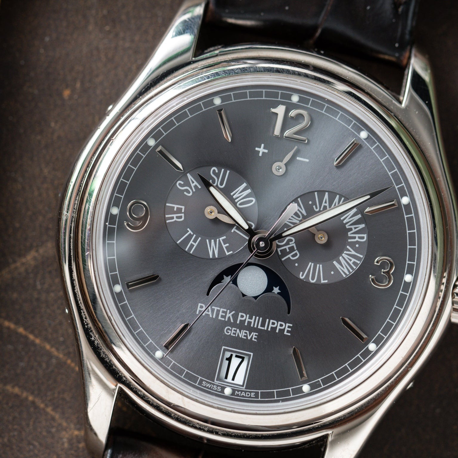 Close-up of the Patek Philippe Annual Calendar wristwatch displaying date, day, month, moon phase, and power reserve indicators.