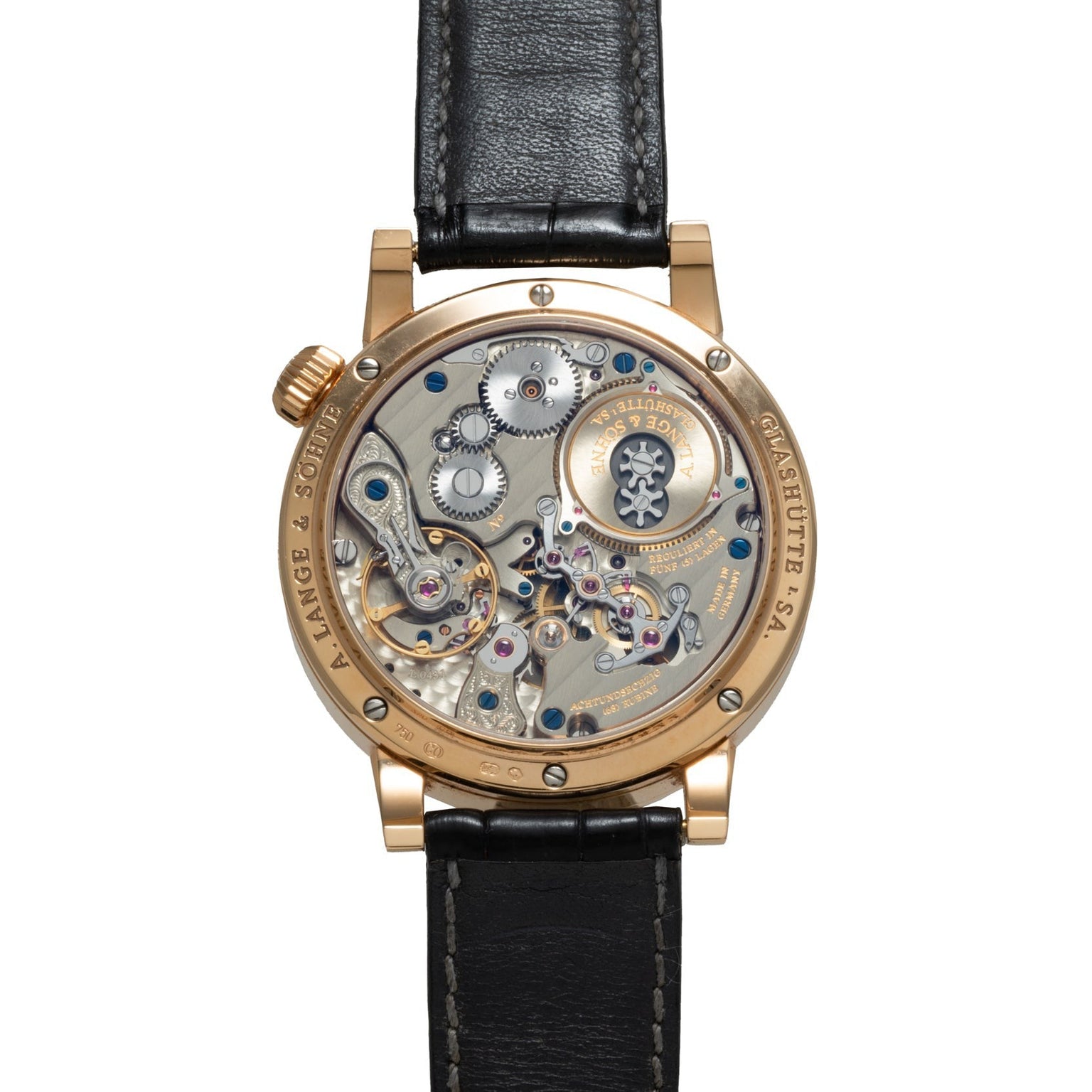 The Zeitwerk by Lange & Sohne features a luxury watch back with exposed intricate gears and mechanisms paired with a black leather strap.