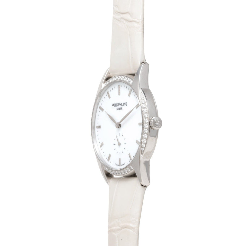 Patek Philippe Calatrava watch with diamond bezel and white leather strap, shown from a side angle.