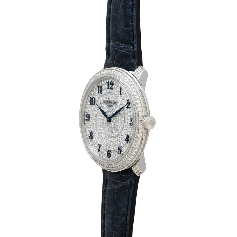 The Patek Philippe Calatrava is a luxury watch featuring a diamond-encrusted face and bezel, black numerals, and a black leather strap.