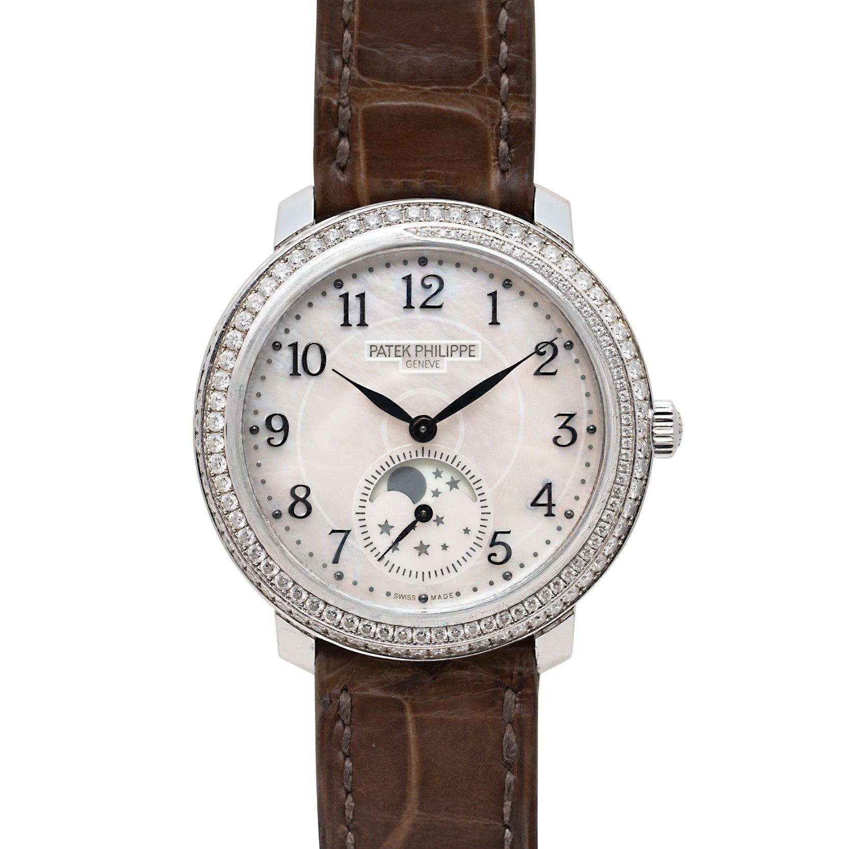 A Patek Philippe Ladies Complication watch featuring a diamond bezel, white dial, moonphase, and brown leather strap.