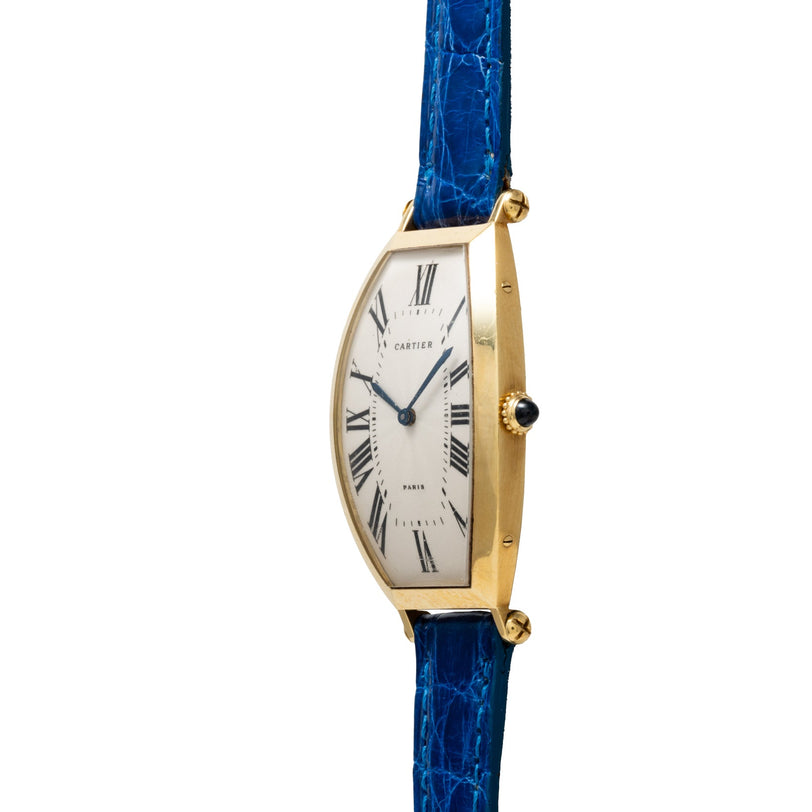 Side view of the Cartier Tonneau XL gold wristwatch featuring a blue leather strap and Roman numeral dial.