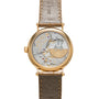 The Patek Philippe Calatrava wristwatch features an exposed mechanical movement and leather strap, viewed from the back.