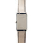 The Jaeger-LeCoultre Reverso Classique Ladies features a silver rectangular case with Reverso engraving and a beige leather strap with visible stitching.