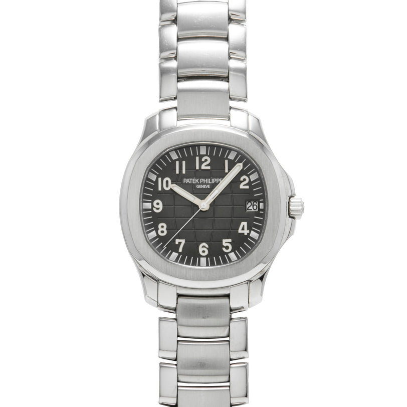 A Patek Philippe Aquanaut wristwatch featuring a silver case, black dial with numbered face, and a date window at 3 o’clock.