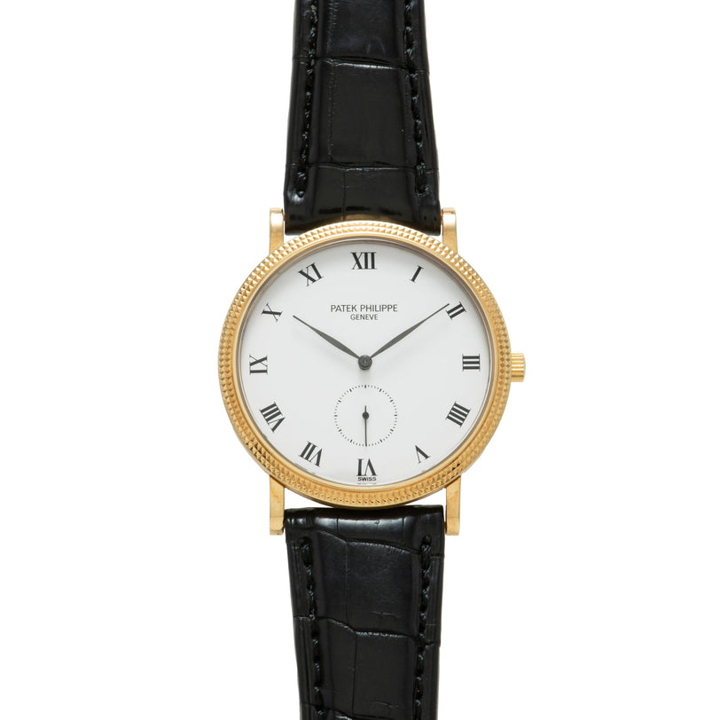 Patek Philippe Calatrava gold watch with black leather strap and white dial featuring Roman numerals.