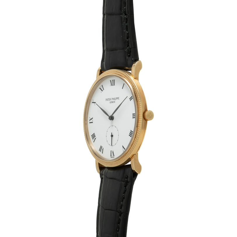 Patek Philippe Calatrava gold wristwatch featuring a white face, Roman numerals, and a black leather strap.