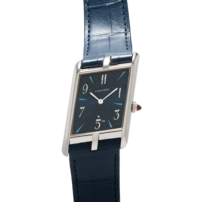 The Cartier Privé Collection Tank Asymétrique New York Edition features a rectangular case, blue leather strap, black dial with silver indices, and blue accents.