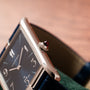 Close-up of the Cartier Privé Collection Tank Asymétrique New York Edition, featuring a rectangular case, blue face, and a red gem in the crown.