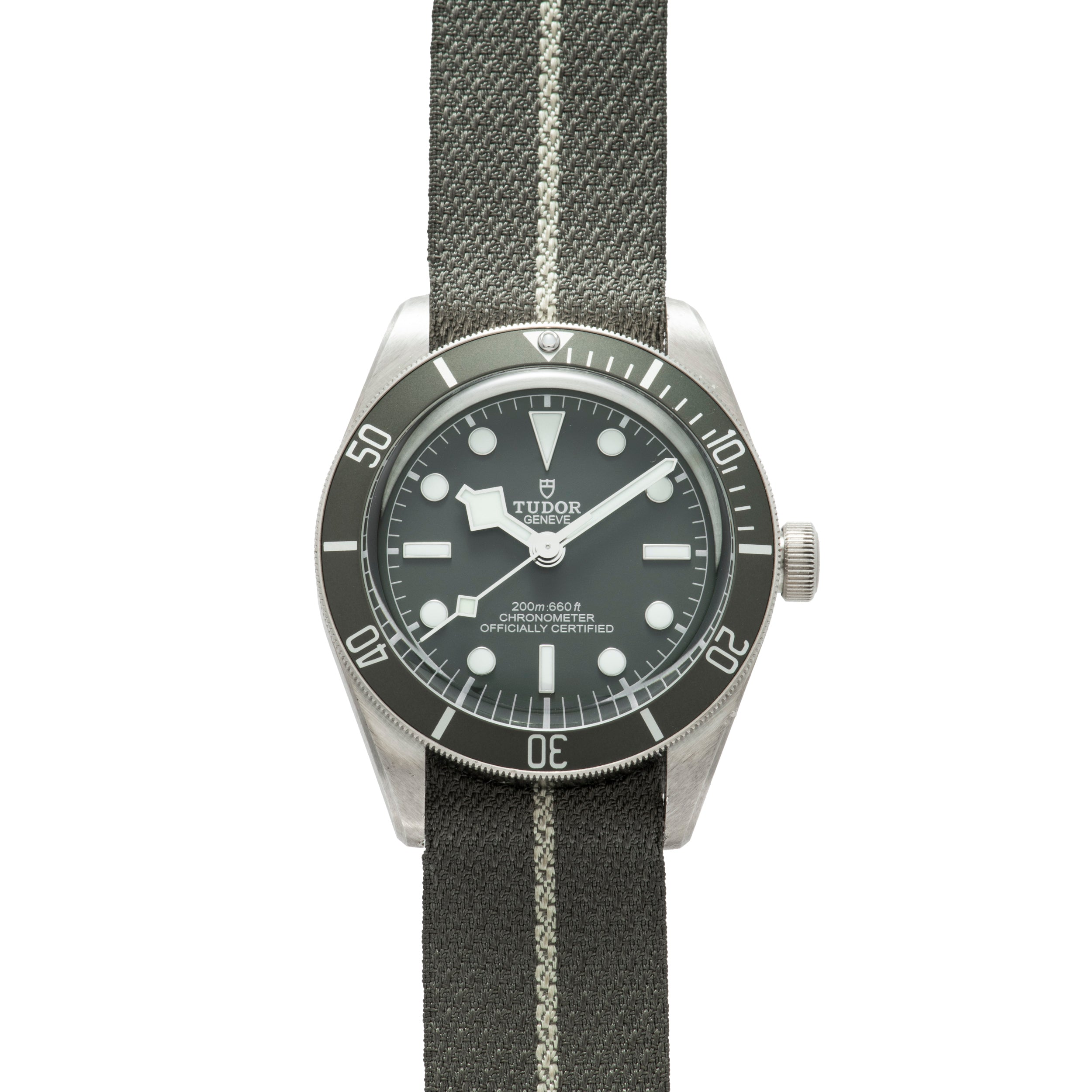 The TUDOR Black Bay 58 Silver features a black dial, rotating bezel, and a gray fabric strap with a white stripe.