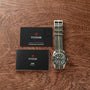 A TUDOR Black Bay 58 Silver watch with a striped strap, warranty card, and user manual displayed on a wooden surface.