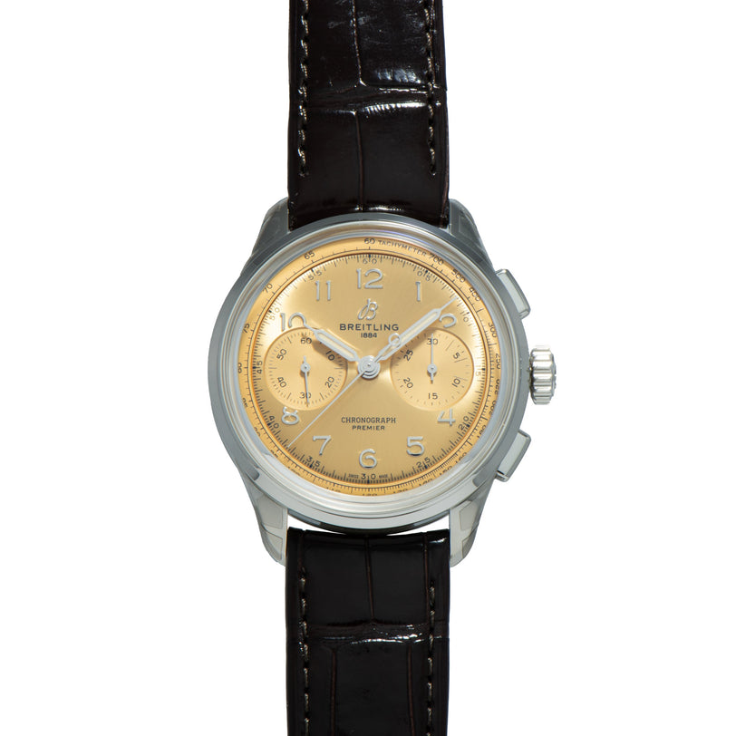 Breitling Premiere B09 Chronograph 40 watch featuring a gold dial, silver case, and black leather strap, shown from the front.