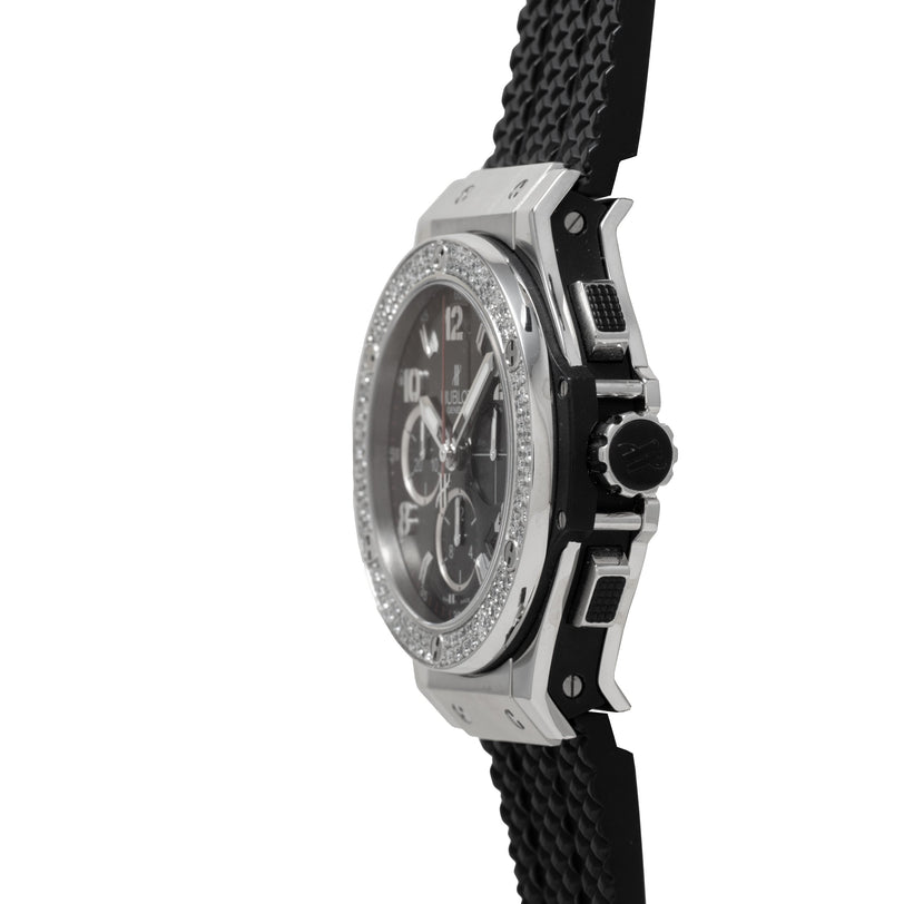 Steel chronograph watch with diamond-set bezel, black dial, and black rubber strap worn on wrist.