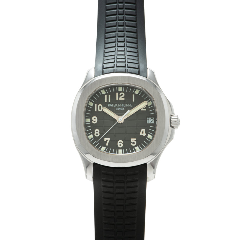 Stainless steel watch with dark dial, Arabic numerals, and black rubber strap with grid pattern.