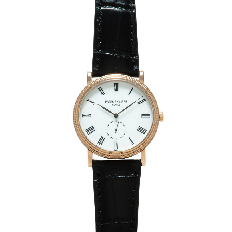 Patek Philippe Calatrava watch with rose gold case, white dial, Roman numerals, and black leather strap.