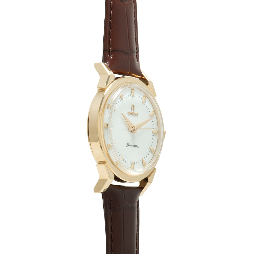 Gold-tone watch with white dial, applied hour markers, and brown leather crocodile-textured strap.