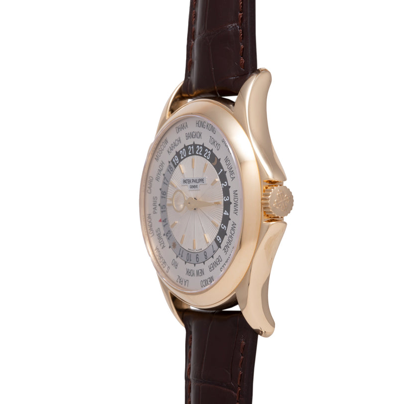 Gold-tone watch with world time zone dial, dark brown leather strap, and textured bezel.