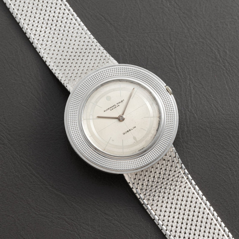 Signed Disco Volante Dress Watch Gübelin by Audemars Piguet with a mesh band resting on a dark leather surface.