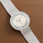 Audemars Piguet Signed Disco Volante Dress Watch Gübelin with a silver mesh bracelet and white dial displayed on a brown leather surface.