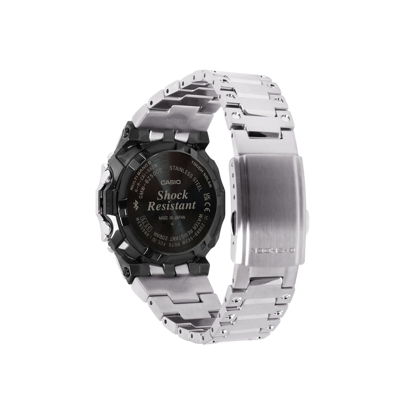 Digital watch with black case, silver stainless steel band, and shock resistant markings on back.