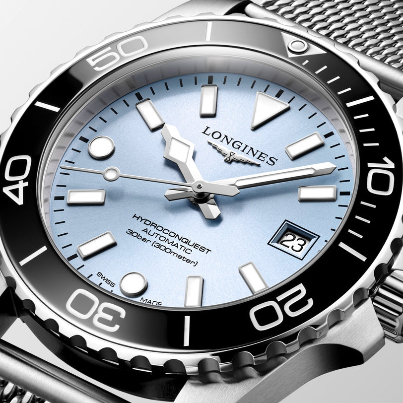 Longines watch with silver bezel and blue dial on a white background