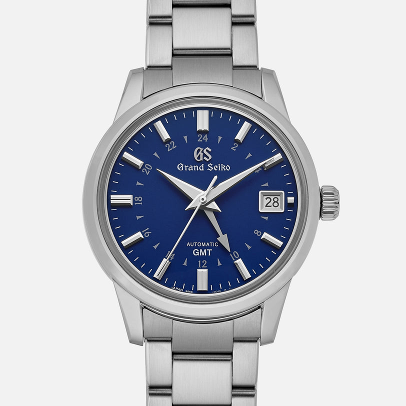 The Grand Seiko Automatic GMT SBGM239 Limited Edition for HODINKEE features a stainless steel case, Twilight Blue dial with silver hour markers, date window at 3 o’clock, and a distinctive GMT hand.