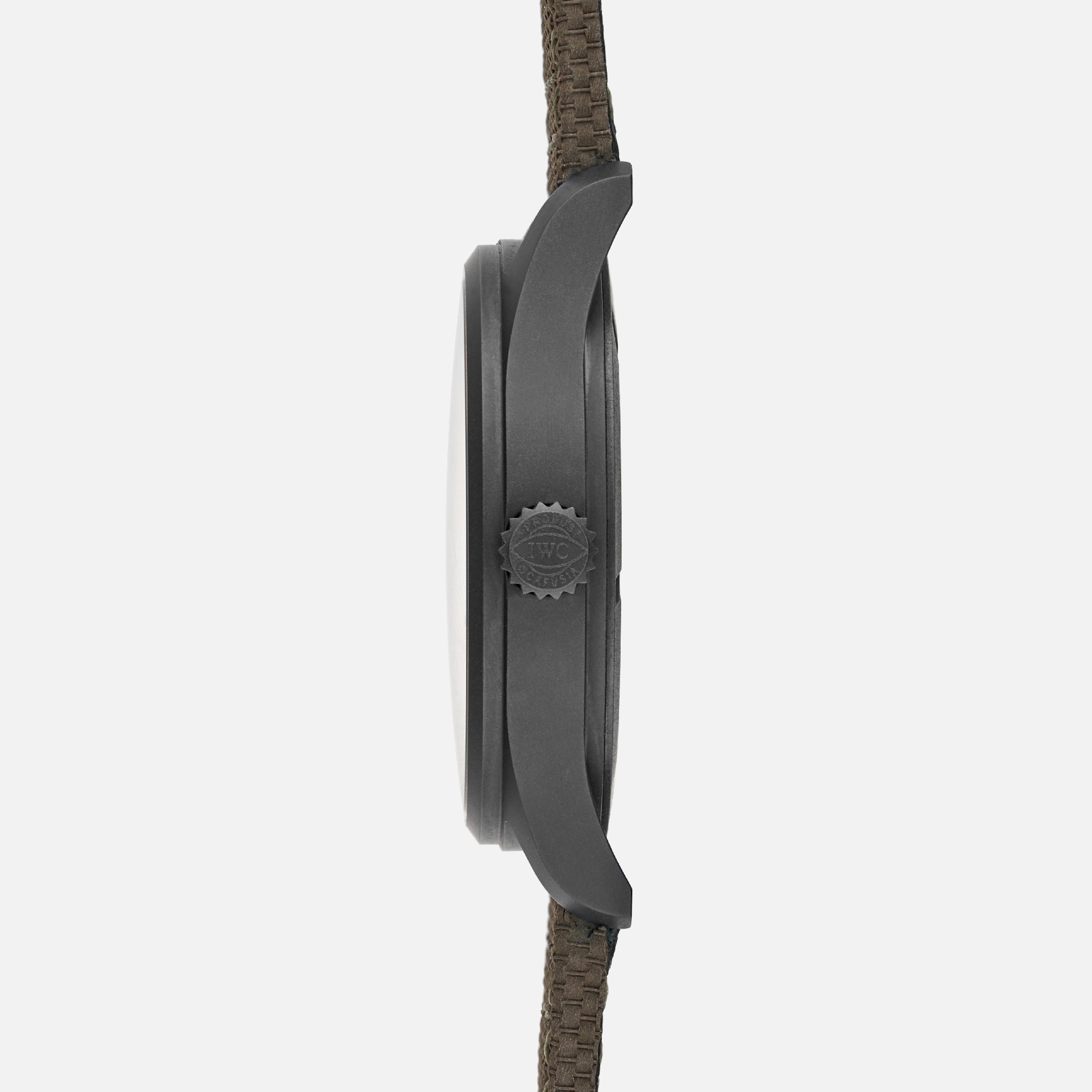 Side view of the IWC Schaffhausen Pilots Watch Mark XVIII Edition HODINKEE by IWC, showcasing its matte dark case, textured crown, and woven fabric strap—crafted as a limited edition.