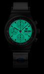 The Porsche Design Chronograph 1 F.A.T 2025 Edition features a glowing teal dial, black case, and displays time and date.
