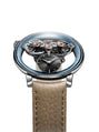 The MB&F SP One Platinum is a luxury watch featuring exposed gears, a blue rim, small black dial, and tan leather strap displayed on a white background.