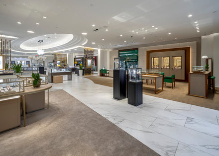 Spacious, well-lit jewelry store with display cases, modern decor, and a mix of tile and carpet flooring.